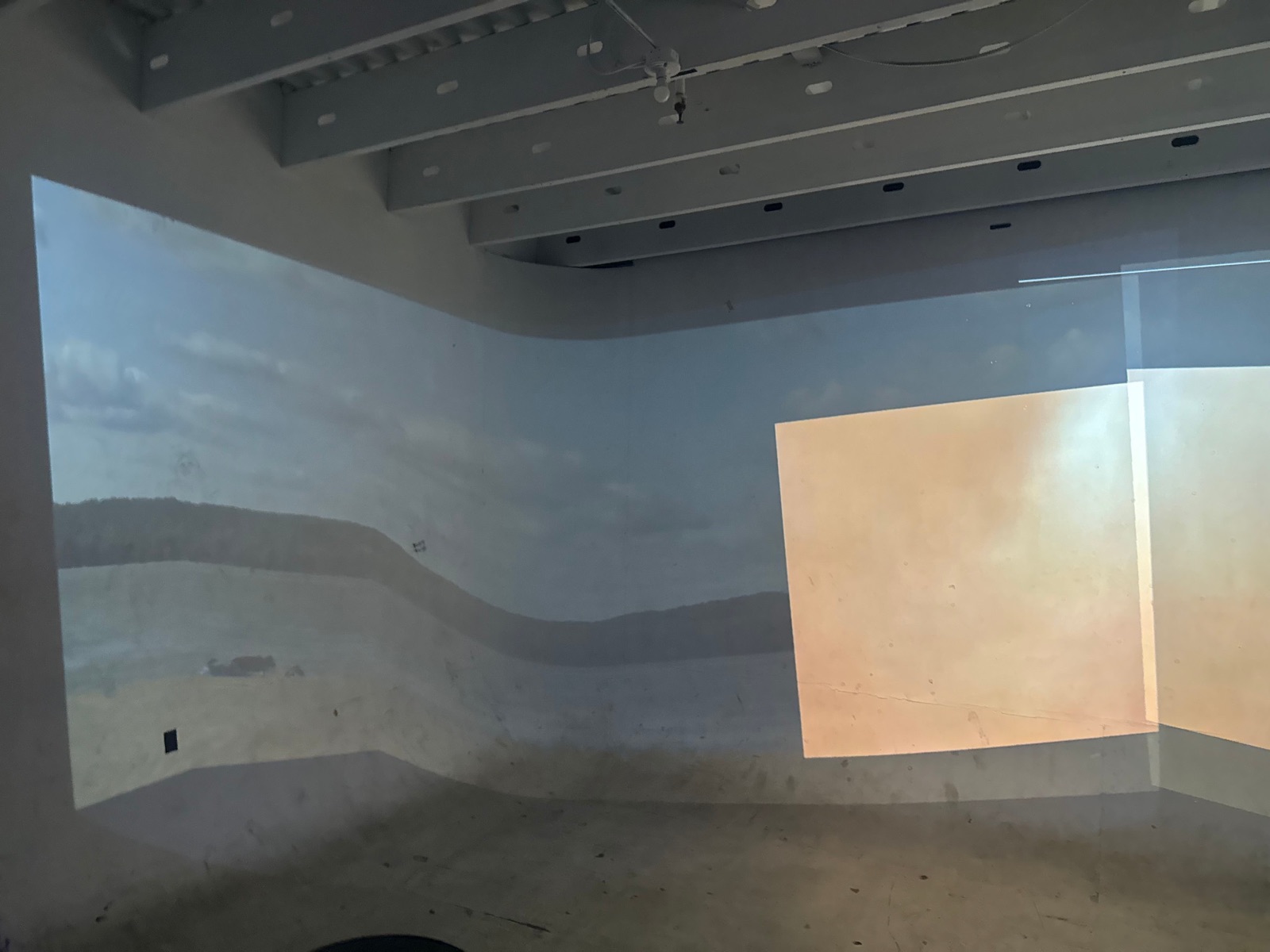 Coastal imagery and a warm rectangular field of light appear on adjoining walls in Coast Echoes.